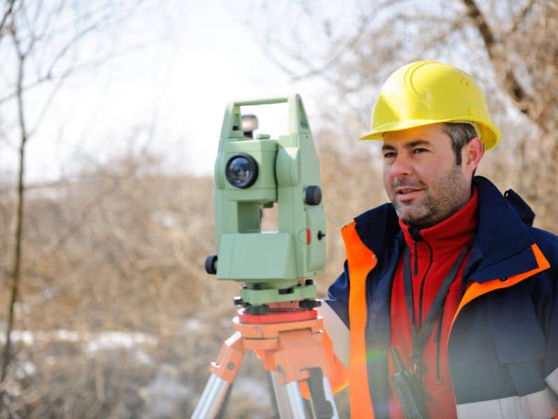 Professional land surveyor using a total station for a property survey in Alexander City, AL